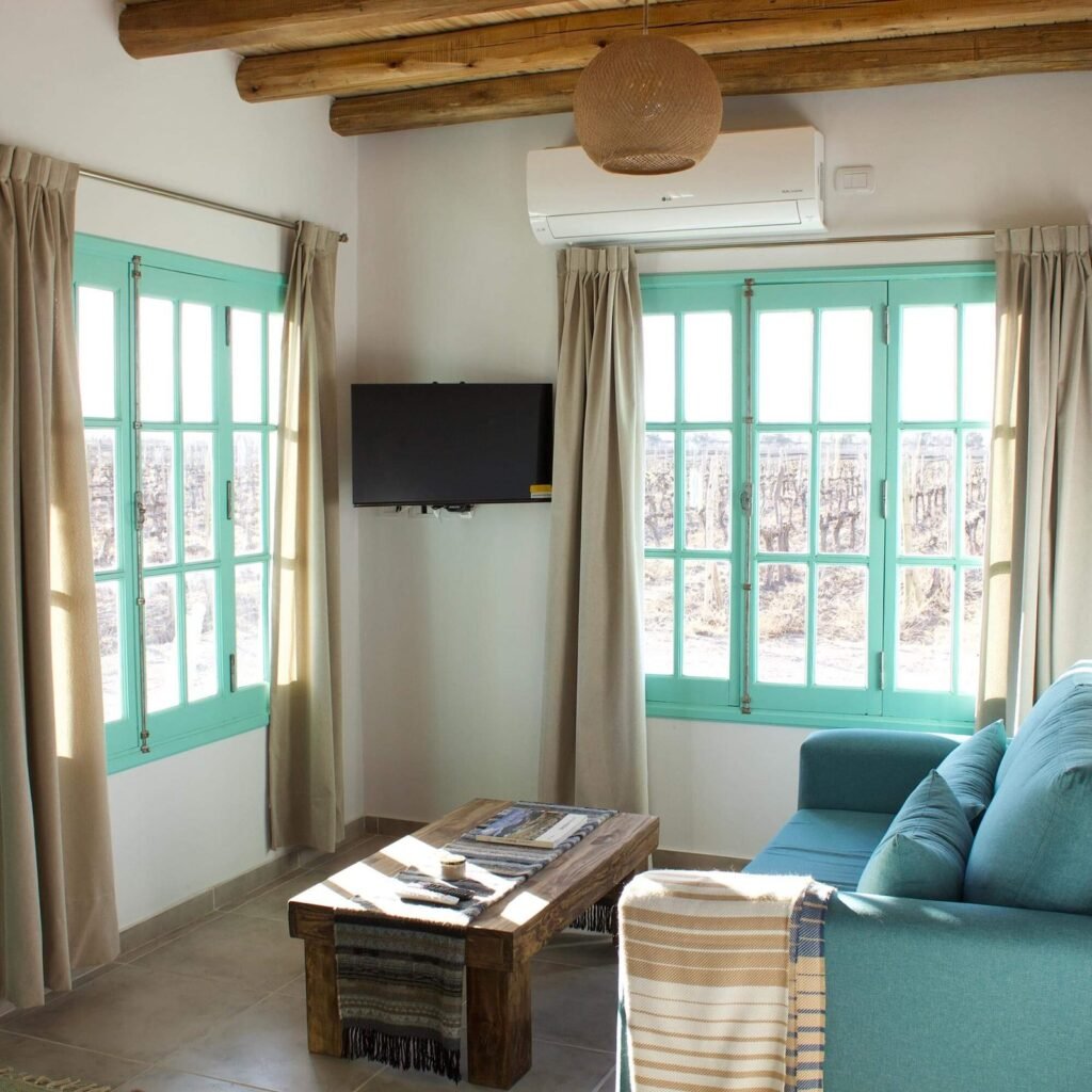 Living de casa Oliva con televisor y vista a la cordillera